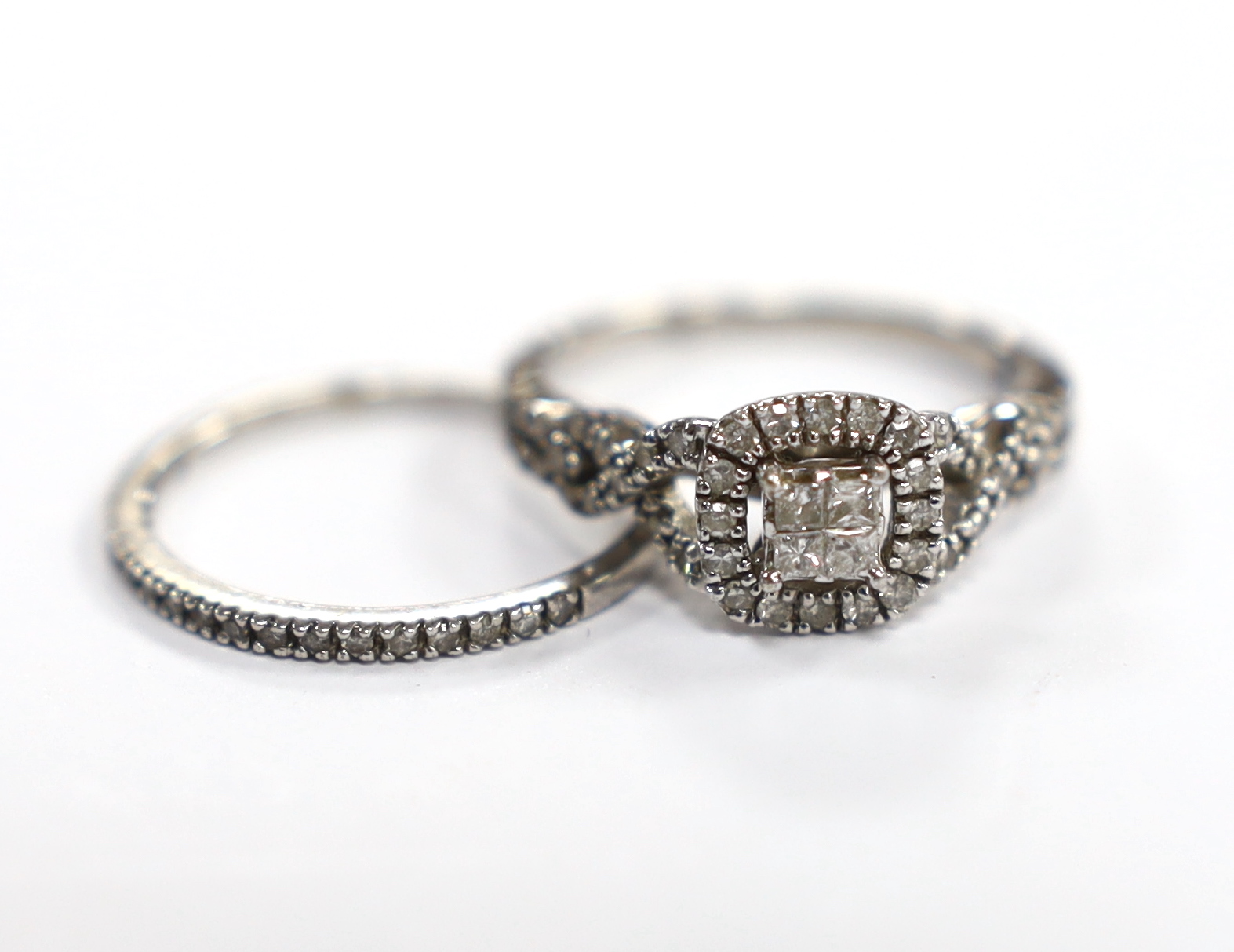 A modern white metal and diamond set cluster ring, with diamond set shoulders size N and a similar diamond chip set half eternity ring, engraved 'Plat', size N, gross weight 4.2 grams.